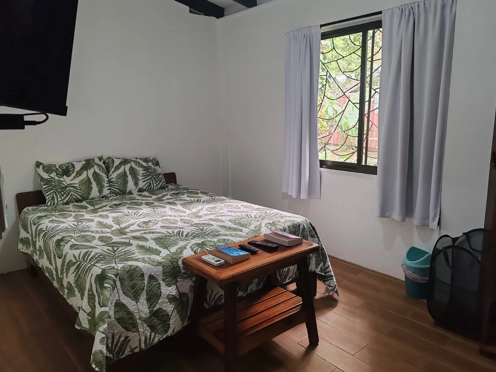 Bedroom 1 with queen bed and palm-print bedding at Sea Señorita Villa, Playa Zancudo Costa Rica