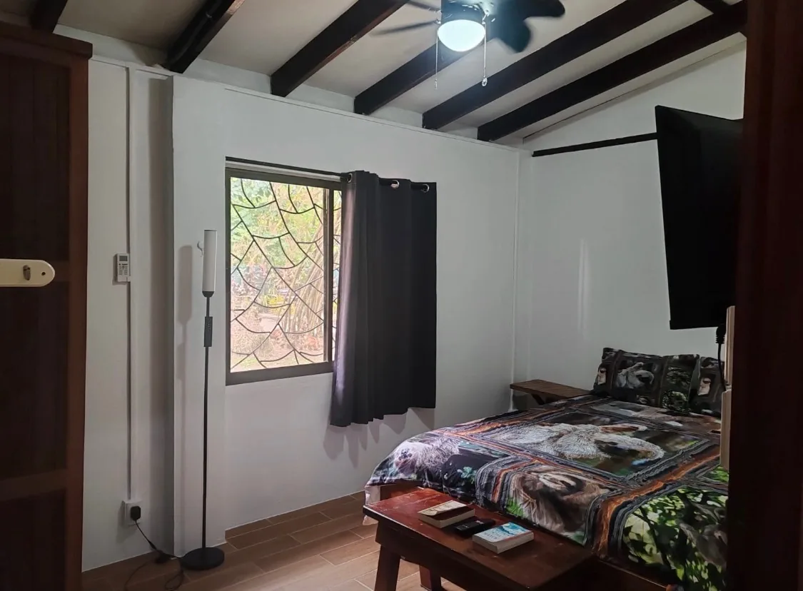 Bedroom 2 with queen bed, ceiling fan and window onto the garden at Sea Señorita Villa
