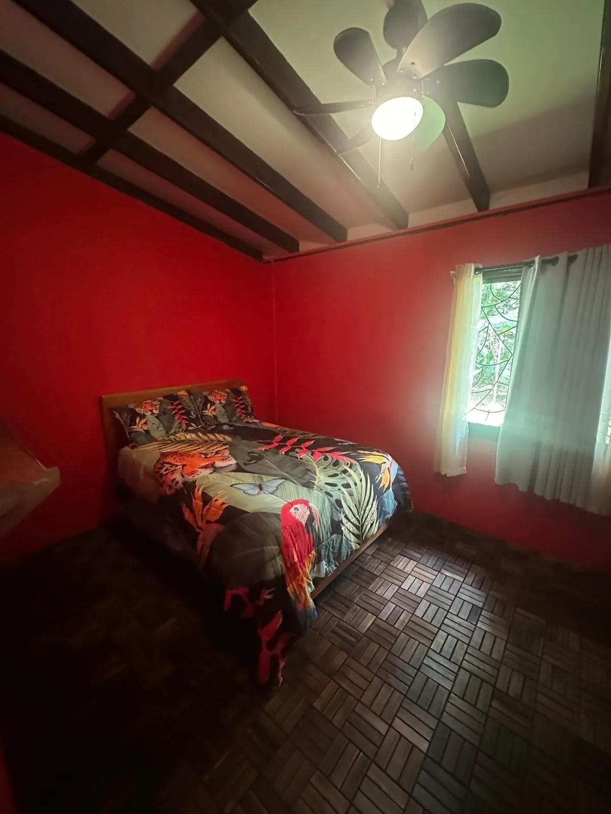 Bedroom 3 with queen bed, red walls and ceiling fan at Sea Señorita Villa