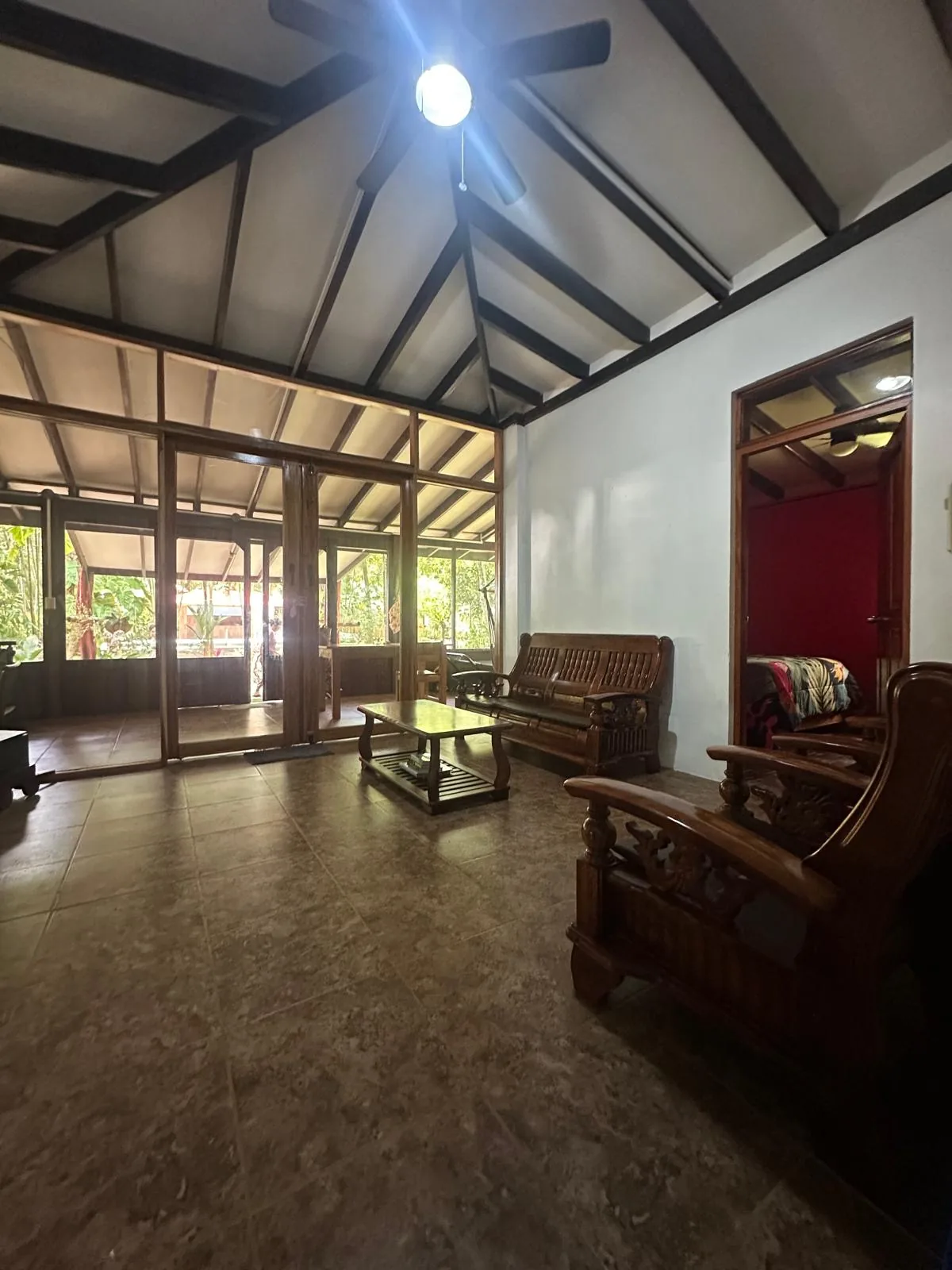 Open living room with hardwood seating and vaulted beamed ceiling at Sea Señorita Villa, Playa Zancudo