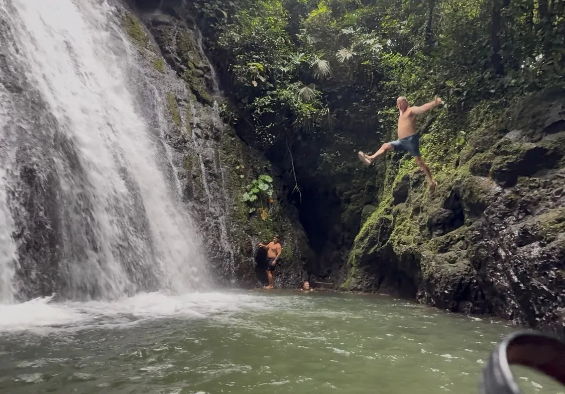Guests jumping into a jungle waterfall pool near Sea Señorita Villa, Costa Rica